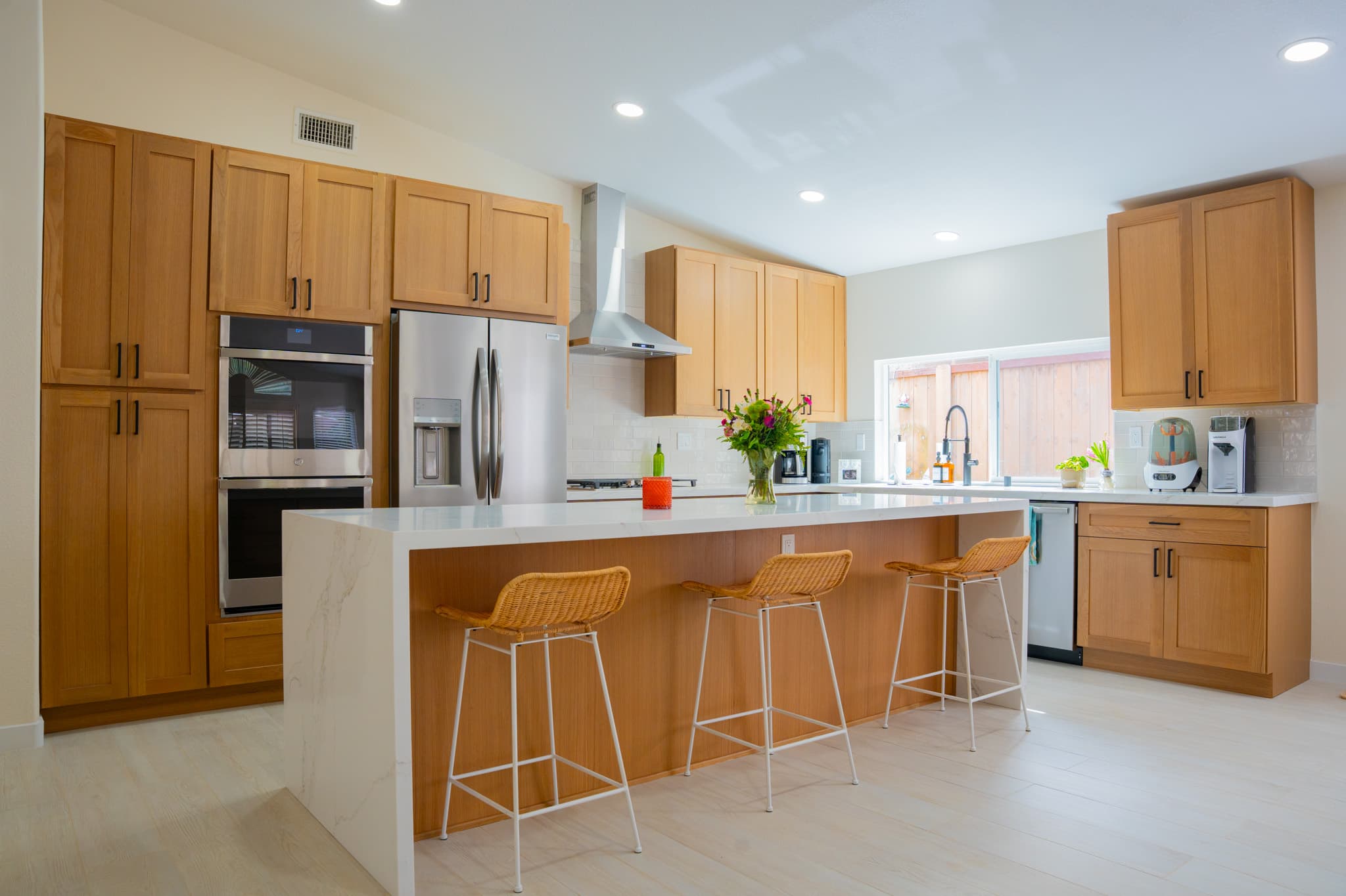 Modern kitchen with custom wood cabinets, stainless steel appliances, and quartz countertops in San Diego