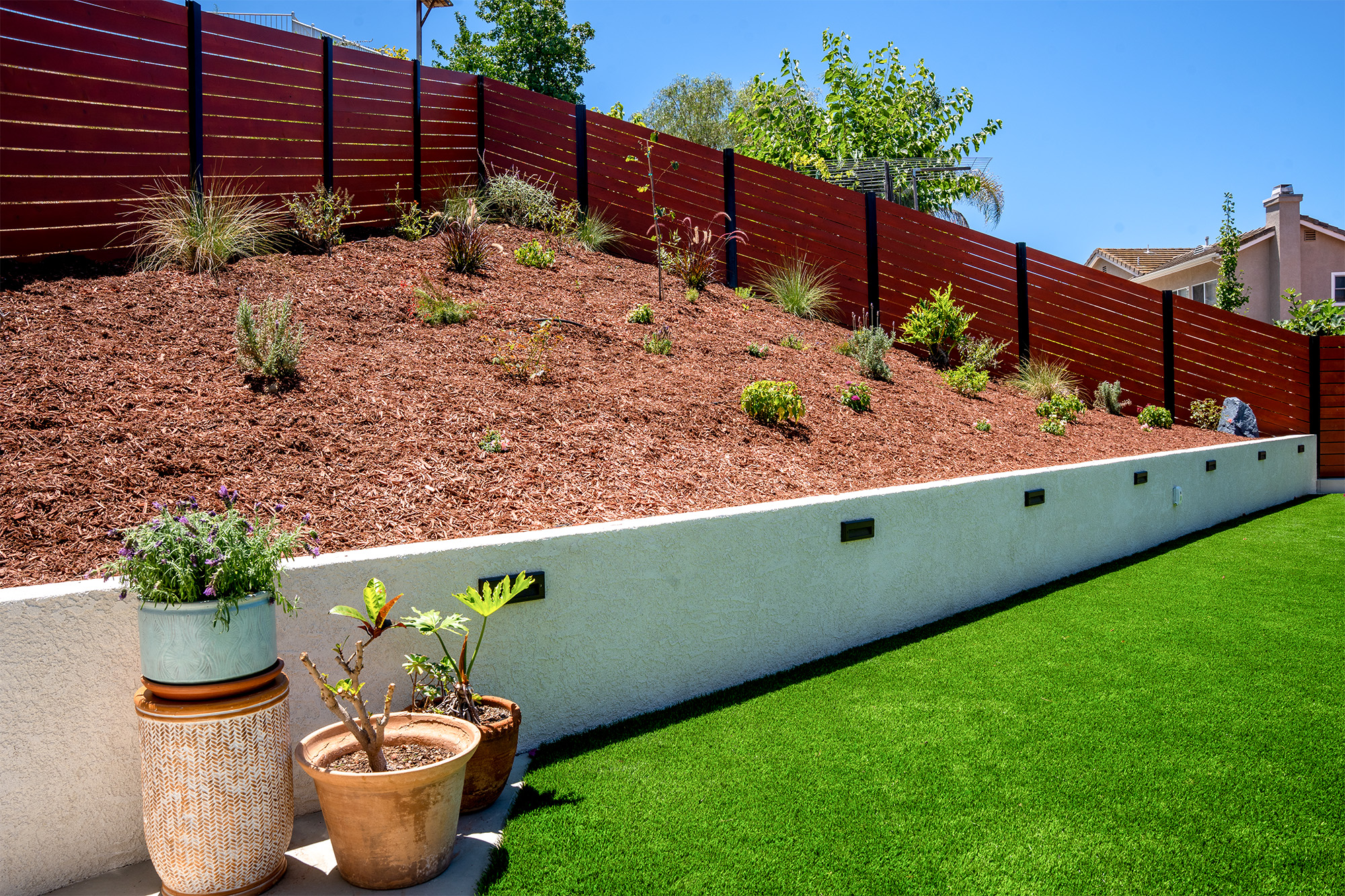 Backyard remodel with artificial turf, retaining wall and landscaping