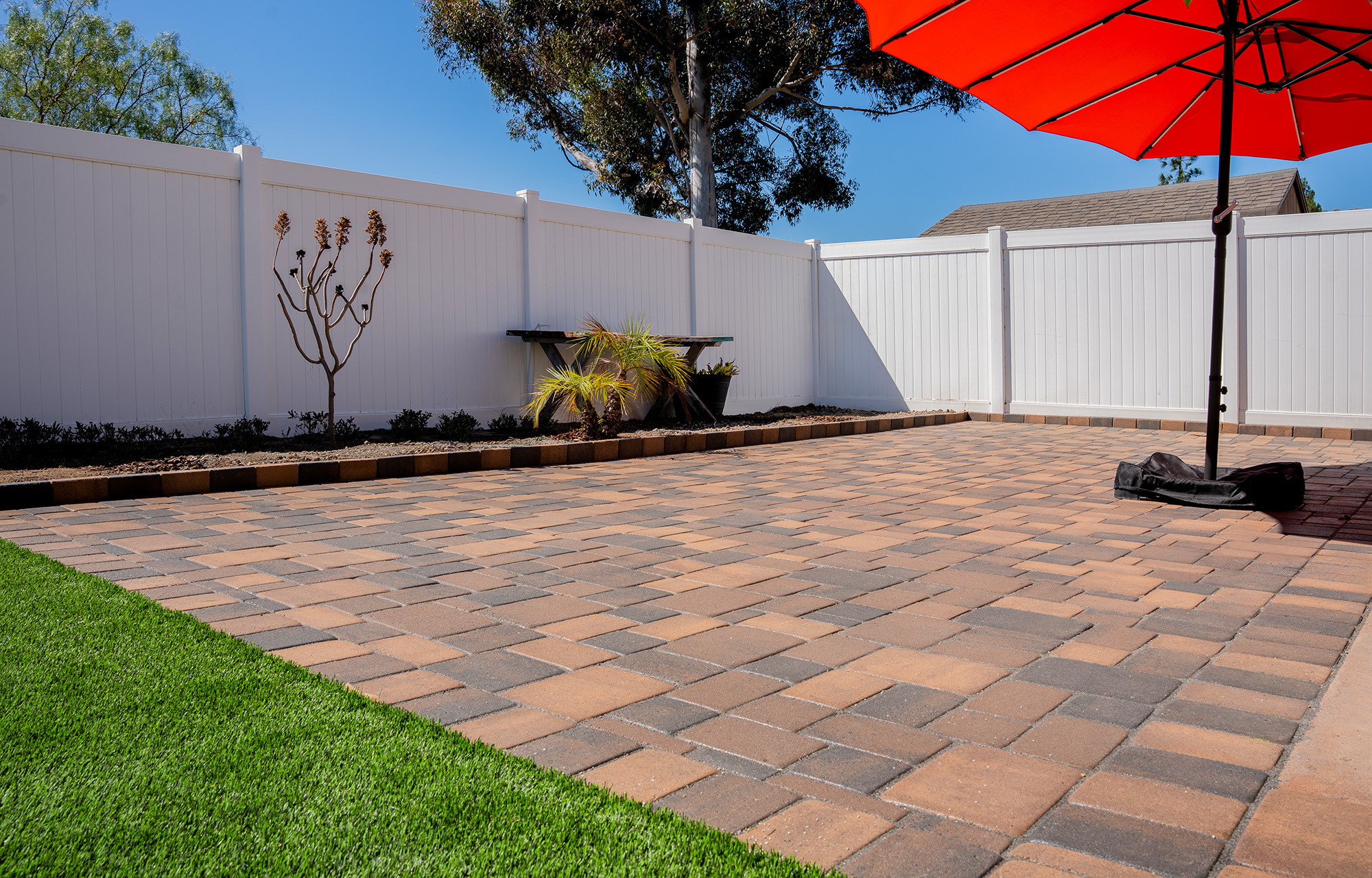 Multi colored pavers witih artificial turf design in San Diego backyard